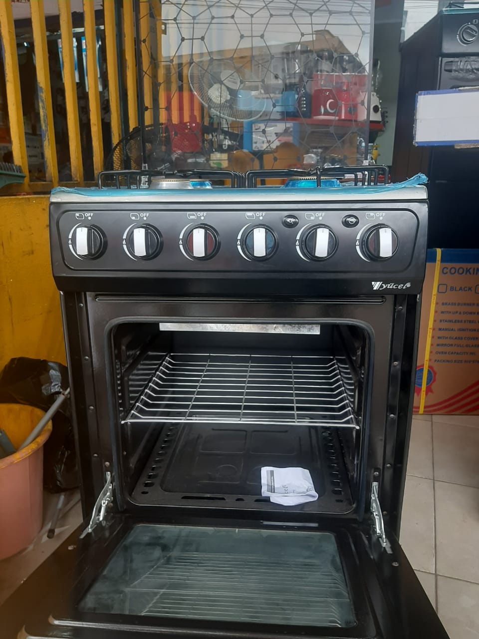 Four de Grande gazinière Yucel 4 feux inox vue de profil avec couvercle vitré